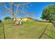 Spacious backyard features lush lawn and mature trees, creating a private and serene outdoor space at 6365 Avocado Dr, Indian Lake Estates, FL 33855