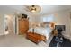Well-lit bedroom with a ceiling fan, a decorative chest, and a view into the living room at 6365 Avocado Dr, Indian Lake Estates, FL 33855