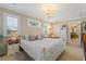Cozy bedroom with a patterned bedspread, stylish lighting, and a decorative stained glass window at 6365 Avocado Dr, Indian Lake Estates, FL 33855