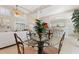 Bright dining area with a glass top table set, overlooking the living room and kitchen at 6365 Avocado Dr, Indian Lake Estates, FL 33855