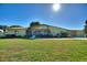 Charming ranch-style home with a screened-in porch, garage, and a well-manicured lawn at 6365 Avocado Dr, Indian Lake Estates, FL 33855