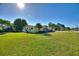 Ranch-style home featuring a well-maintained lawn, mature trees and fenced backyard at 6365 Avocado Dr, Indian Lake Estates, FL 33855