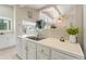 Bright kitchen with stainless steel sink and white tile countertops with a garden window for natural light at 6365 Avocado Dr, Indian Lake Estates, FL 33855