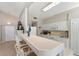 Bright kitchen with white cabinetry, tiled countertops, and a breakfast bar for casual dining at 6365 Avocado Dr, Indian Lake Estates, FL 33855