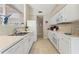 Well-lit kitchen featuring white cabinets, tiled countertops, and ample counter space for cooking at 6365 Avocado Dr, Indian Lake Estates, FL 33855