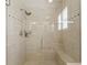 Modern walk-in shower with glass door, built-in bench, and tiled walls at 6365 Avocado Dr, Indian Lake Estates, FL 33855