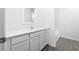 Modern bathroom featuring white cabinetry, stone countertops and wood look floors at 13279 Tula Loop, Astatula, FL 34705