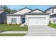 Charming single-Gathering home with a well-maintained lawn, blue door, and two-car garage at 13279 Tula Loop, Astatula, FL 34705