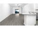 Bright living room with gray wood floors, white walls, and sliding glass doors to the backyard at 13279 Tula Loop, Astatula, FL 34705
