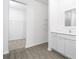 Bright bathroom featuring wood-look floors, double sink vanity, and walk-in closet access at 13283 Tula Loop, Astatula, FL 34705