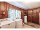 Utility room showcasing wood paneled walls and equipped with washer, dryer and water heater at 4290 Trainer Rd, Bartow, FL 33830