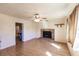 Bright living room with a brick fireplace, ceiling fan, and wood-look flooring at 4290 Trainer Rd, Bartow, FL 33830