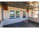Covered porch featuring a ceiling fan, door, and windows, creating an inviting outdoor space at 4290 Trainer Rd, Bartow, FL 33830