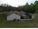 Back of house with a screened-in pool at 4586 Cr 696, Webster, FL 33597