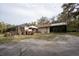 Screen enclosed lanai, outdoor stone fireplace and grill area. Surrounded by sparse trees at 4586 Cr 696, Webster, FL 33597