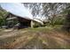 A backyard featuring a large screened-in lanai, mature trees, and ample space for outdoor activities at 4586 Cr 696, Webster, FL 33597