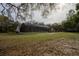 Large lawn, partially screen-enclosed lanai, surrounded by sparse trees at 4586 Cr 696, Webster, FL 33597