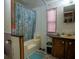 Modest bathroom featuring tub with blue shower curtain, and wood vanity at 4586 Cr 696, Webster, FL 33597