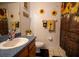 Sun-themed bathroom with sunflower decor, light wood cabinets, and a shower at 4586 Cr 696, Webster, FL 33597