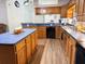 Spacious kitchen features wood cabinets, blue countertops, black appliances, and wood flooring at 4586 Cr 696, Webster, FL 33597