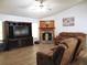 Comfortable living room with wood-burning fireplace, ceiling fan, and recliner seating at 4586 Cr 696, Webster, FL 33597
