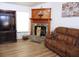 Living room featuring a stone fireplace, mounted TV, and a comfortable brown sofa at 4586 Cr 696, Webster, FL 33597
