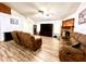 Bright living room with ceiling fan, wood-look floors, and fireplace, with a brown sofa at 4586 Cr 696, Webster, FL 33597