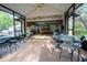 Covered patio with tables and chairs and view into game room at 4586 Cr 696, Webster, FL 33597