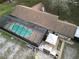Aerial view of the screen enclosed pool next to outdoor kitchen area, with white umbrella at 4586 Cr 696, Webster, FL 33597