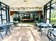 Inside covered pool room with stone wall, wet bar, pool table, overhead fan, and tiled floor at 4586 Cr 696, Webster, FL 33597