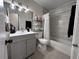 Clean bathroom featuring vanity with sink, well-lit mirror, toilet, shower with white curtain and tiled walls at 5835 Talavera St, Orlando, FL 32807