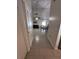 Hallway view towards the living room and dining table with neutral paint, tile floors and doors on either side at 5835 Talavera St, Orlando, FL 32807