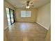An open living room has a sliding glass door leading outside, a ceiling fan, and neutral paint at 5835 Talavera St, Orlando, FL 32807