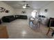 Spacious living room featuring tile floors, dark sofas, dining table, ceiling fan and large light-filled windows at 5835 Talavera St, Orlando, FL 32807