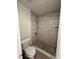 Beautifully remodeled bathroom with modern tile shower, stone floor, and new fixtures next to a toilet at 5835 Talavera St, Orlando, FL 32807