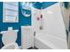 Bright bathroom features a white tub and shower, vanity, and blue painted walls at 1043 Pineview Pl, Lakeland, FL 33801