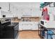 Bright kitchen featuring white cabinets, white appliances, and wood-look flooring at 1043 Pineview Pl, Lakeland, FL 33801
