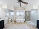 Bright bathroom with a soaking tub, an enclosed shower, modern fixtures, and hardwood floors at 1905 Seminole Trl, Lakeland, FL 33803