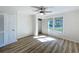 Bright bedroom featuring hardwood floors, a ceiling fan, two windows and an open closet at 1905 Seminole Trl, Lakeland, FL 33803