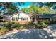 Charming home featuring a brick facade, lush landscaping, a blue front door, and a circular driveway at 1905 Seminole Trl, Lakeland, FL 33803