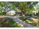 Beautifully landscaped property offering a spacious driveway, mature trees, and a welcoming front porch at 1905 Seminole Trl, Lakeland, FL 33803