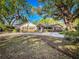 Charming home featuring a brick facade, lush landscaping, a blue front door, and a circular driveway at 1905 Seminole Trl, Lakeland, FL 33803