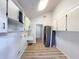 Well-lit laundry room with white cabinets, sink, and modern washer and dryer; wood-look floors add warmth at 1905 Seminole Trl, Lakeland, FL 33803