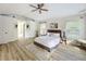 Bright main bedroom featuring hardwood floors, a ceiling fan, two windows, and a stylish sitting area at 1905 Seminole Trl, Lakeland, FL 33803