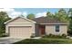 Charming single-story home showcasing a classic design with a well-manicured lawn and inviting entrance at 2430 Slippery Rock St, Auburndale, FL 33823