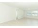 A spacious living area with tile flooring, large windows, and neutral paint at 2430 Slippery Rock St, Auburndale, FL 33823