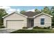 Charming single-story home featuring a neutral color, a two-car garage and manicured landscaping at 2446 Slippery Rock St, Auburndale, FL 33823