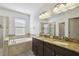 Bathroom with a soaking tub, dual sinks, granite countertops, and tiled shower at 8983 Azalea Sands Ln # 8983, Davenport, FL 33896