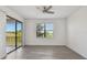 Bright, airy bedroom featuring gray wood-look floors, a ceiling fan, and sliding doors to a balcony at 8983 Azalea Sands Ln # 8983, Davenport, FL 33896