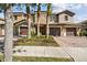 Well-manicured townhome featuring a two-car garage, paver driveway, and lush landscaping at 8983 Azalea Sands Ln # 8983, Davenport, FL 33896